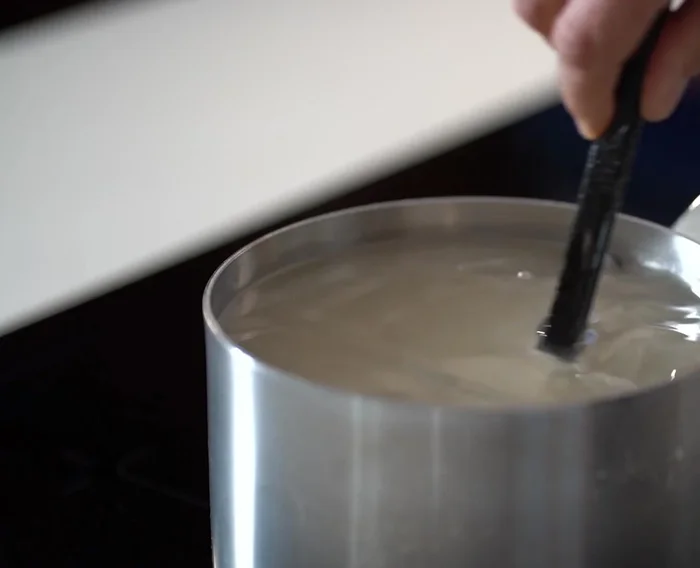 Préparez le sirop : chauffez de l'eau et du sucre dans une casserole jusqu'à obtenir un sirop épais. Laissez mijoter à feu doux en remuant.