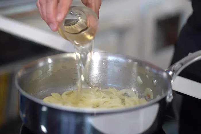 Déglacer avec du vin blanc, ajouter la citrouille, les pommes de terre, la sauge ou le thym et le bouillon de poulet.