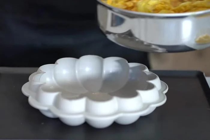Remplir le moule à gâteau en silicone avec le mélange de citrouille et de pommes de terre et du fromage râpé.