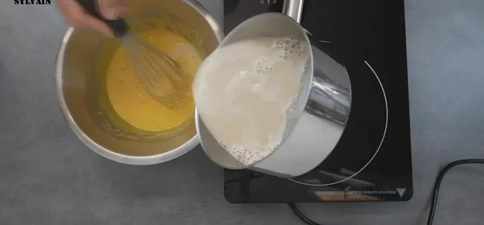 Cuire la crème d'amande : Verser le lait d'amande bouillant sur le mélange aux jaunes d'œufs. Mélanger, transvaser dans une casserole et cuire à ébullition pendant 1 minute.