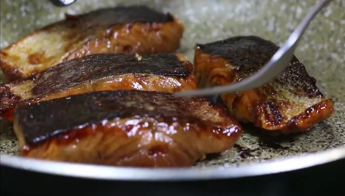 Ajouter les filets de saumon, côté peau vers le bas, et assaisonner avec du sel et du poivre.