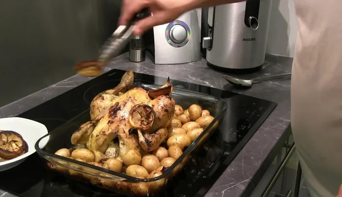 10 minutes avant la fin de la cuisson, sortir le poulet, retirer les rondelles de citron, et frotter le poulet avec les demi-citrons.