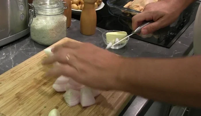 Couper grossièrement l'oignon et le disposer autour du poulet.