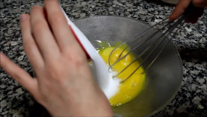 Préparez la crème pâtissière : mélangez les jaunes d'œuf, le sucre et le sucre vanillé jusqu'à ce que le mélange blanchisse. (80)