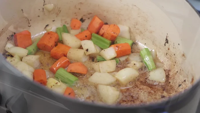 Retirer l'excès de graisse de la casserole. Ajouter une cuillère à soupe de beurre et faire revenir les légumes (oignon, carotte, céleri) coupés grossièrement pendant 1-2 minutes.