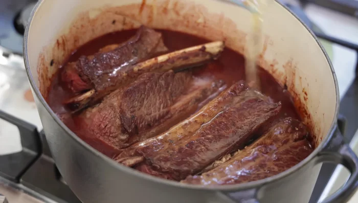 Ajouter le bouillon de bœuf pour partiellement immerger la viande.