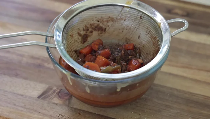 Filtrer la sauce pour retirer les légumes et les épices. Retirer l'excès de graisse.