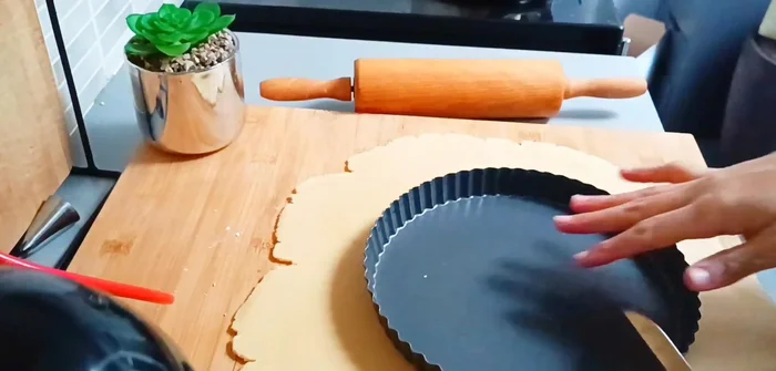 Étaler la pâte et la placer dans le moule à tarte. Piquer la pâte avec une fourchette.