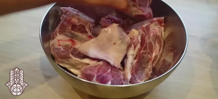 Couper l'agneau en morceaux. Mariner la viande avec le curcuma, le gingembre, le poivre noir, vert et blanc, le ras el hanout, le safran (dilué dans un peu d'eau), et le sel. Bien malaxer pour enrober la viande.