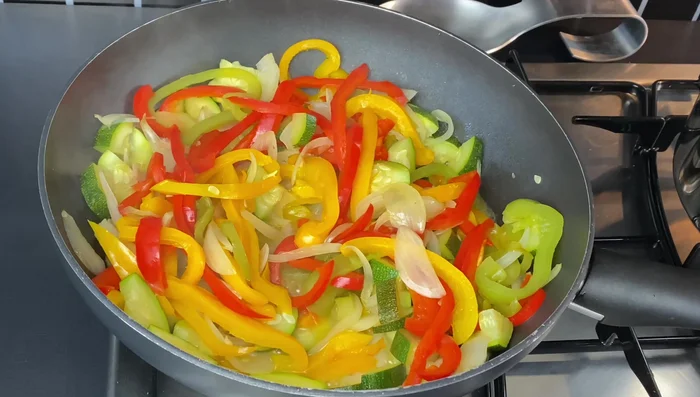 Ajouter la sauce soja, le concentré de tomate (facultatif), le cumin, le poivre, le gingembre, le piment doux, l'ail haché, le sel et les sachets d'assaisonnement des nouilles (si inclus).