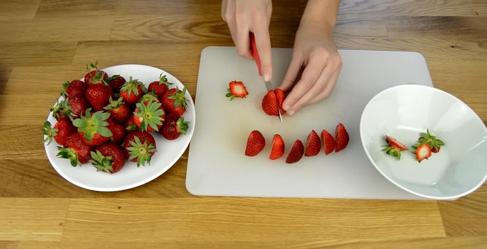 Préparer les fraises : Laver, équeuter et couper les fraises. Séparer les fraises pour la décoration extérieure des autres.