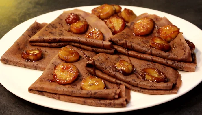 Servir les crêpes avec les bananes caramélisées et du chocolat fondu (facultatif).