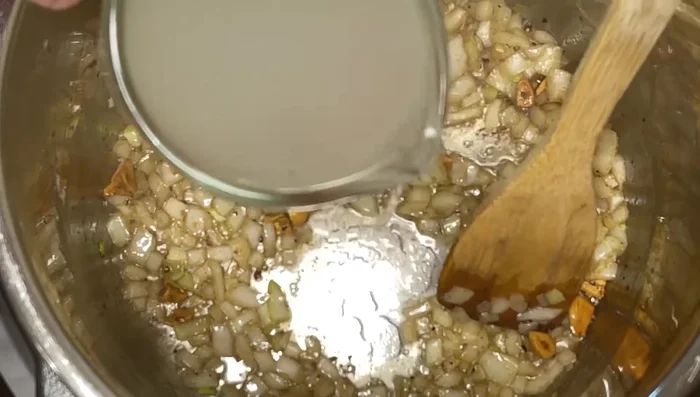Ajouter le bouillon à la casserole, bien gratter le fond pour récupérer les sucs.