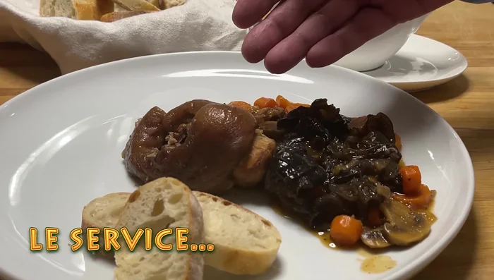 Servir le jarret de porc avec les carottes et les champignons, nappé de sauce.