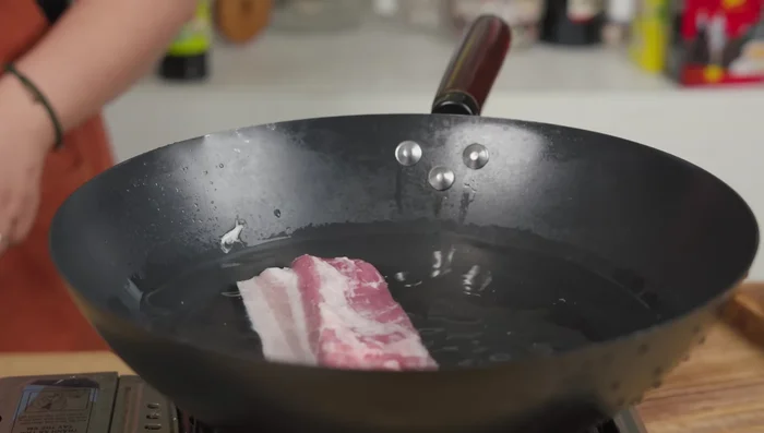 Faites cuire le porc (154.519) avec un demi-oignon dans de l’eau bouillante pendant 18 minutes environ (162.319). Laissez refroidir et coupez en fines bouchées (177.92).