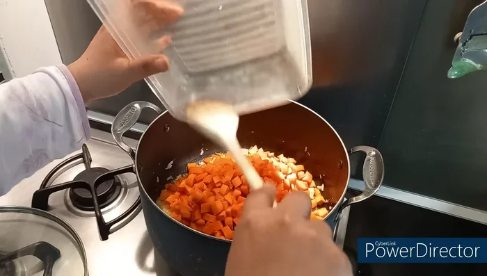 Ajouter les carottes, pommes de terre et courgettes coupées en cubes à la marmite. Rajouter le cube de légumes émietté, un peu d'eau, couvrir et laisser cuire 15-20 minutes en mélangeant de temps en temps.
