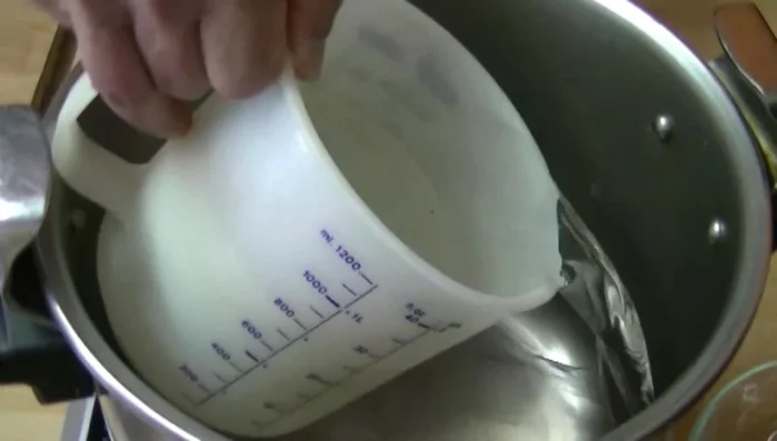 Dans une grande casserole, faites chauffer 1L d'eau. Ajoutez les morceaux d'oranges et le sucre.