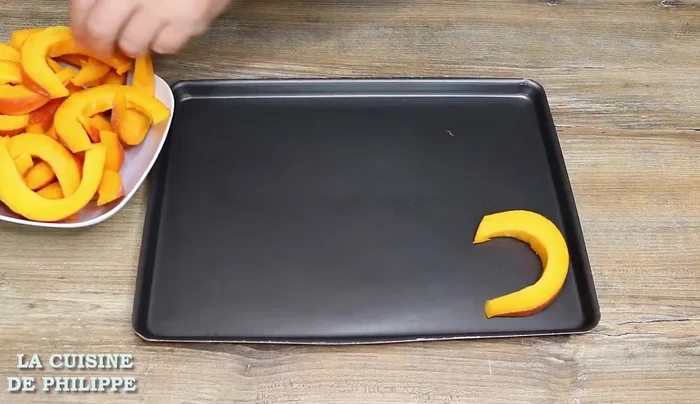 Disposer les tranches de potimarron sur une plaque à four, en les arrangeant pour gagner de la place.
