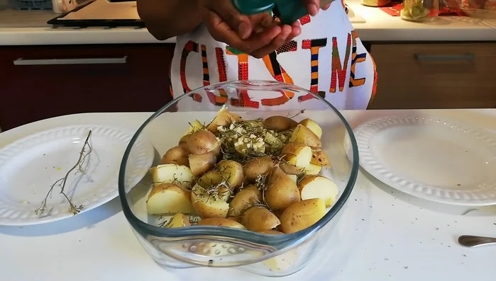 Dans un bol, mélanger les pommes de terre avec l'ail écrasé, le thym, le romarin, l'origan, le poivre noir, le sel et l'huile d'olive. (114.58) Ne pas mettre trop d'huile, de sel ou d'épices. (150.76)