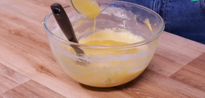 Versez le jus de cuisson des fruits dans la pâte à cake.