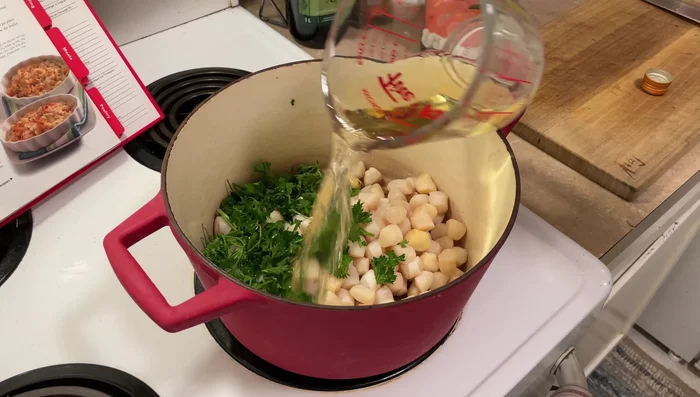 Dans une poêle, faire revenir les pétoncles avec le persil et un peu de vin blanc. Ajouter de l'eau et porter à ébullition, puis laisser mijoter 6 minutes avec du sel.