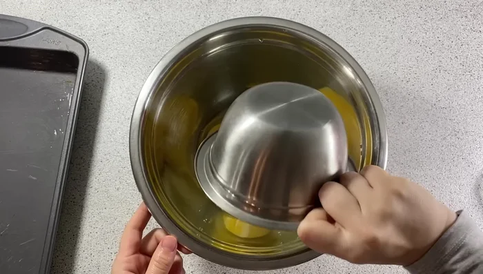 Dans un grand récipient, fouetter énergiquement 3 œufs avec 150g de sucre jusqu'à blanchissement (3-4 minutes).