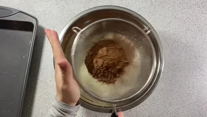 Tamiser 30g de cacao non sucré et ajouter à la préparation.