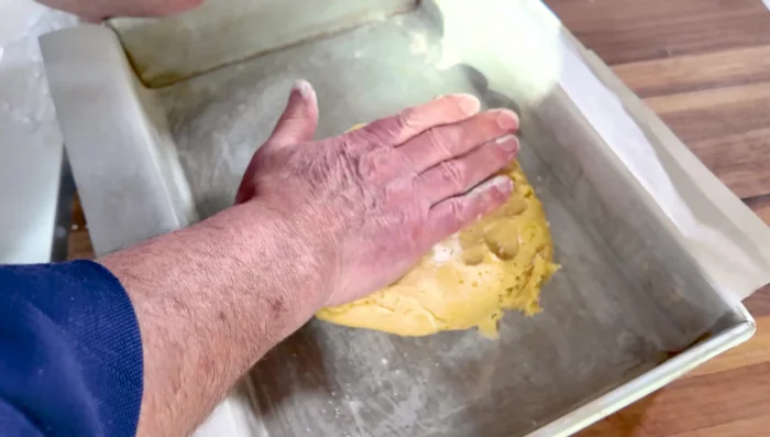 Étaler la pâte dans un moule tapissé de papier sulfurisé.