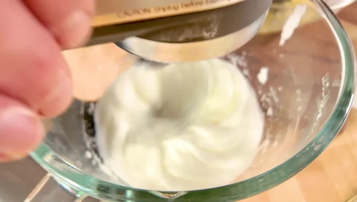 Monter les blancs d’œufs en neige ferme avec 1-2 cuillères à soupe de sucre.