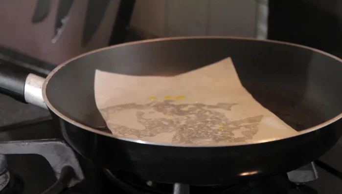 Faites chauffer une poêle à feu vif. Disposez le pavé de saumon sur du papier sulfurisé dans la poêle.