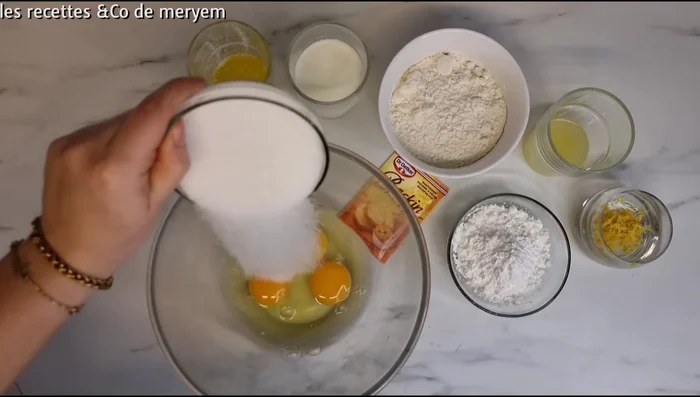 Préparation du cake au citron: mélanger les œufs, le sucre, le sel, puis ajouter le beurre fondu et la crème.