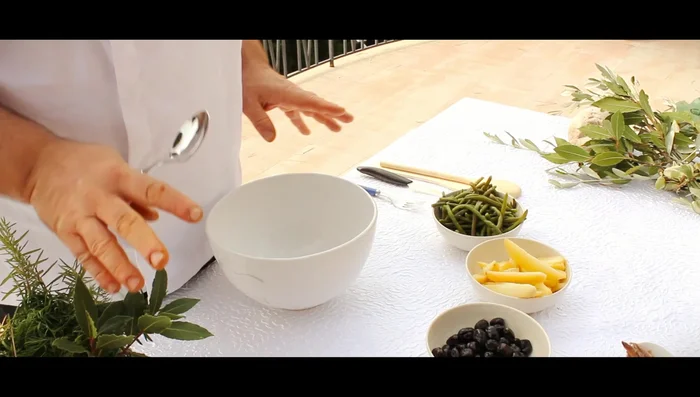 Réaliser l'assemblage des crudités : haricots verts, oignons rouges, concombres, poivrons rouges.