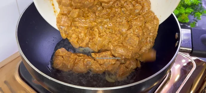 Faire revenir le poulet mariné dans l'huile chaude jusqu'à ce qu'il soit doré et que l'eau s'évapore (environ 4-5 minutes).