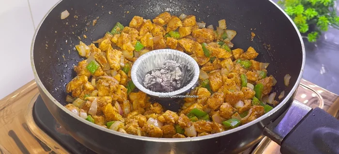 Ajouter le charbon de bois chaud et laisser fumer pendant 2 minutes pour donner une saveur fumée.