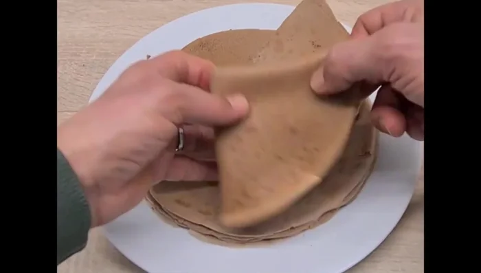 Plier les crêpes en triangle et ajouter un filet de pâte à tartiner supplémentaire pour la décoration.