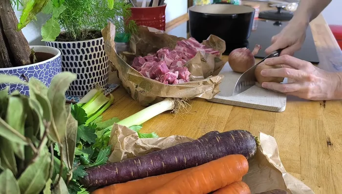 Transférer le tout dans une cocotte ou un faitout. Ajouter de l'eau ou du bouillon si nécessaire pour couvrir la viande.
