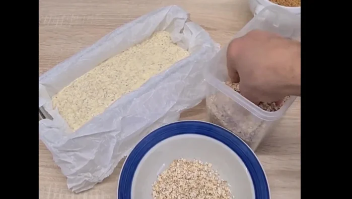 Parsemer le dessus du pain avec un mélange de flocons d'avoine, graines de chia et graines de lin.