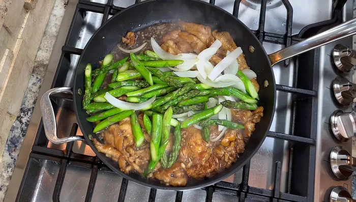 Ajouter l'oignon, les asperges et du poivre noir concassé. Mélanger.