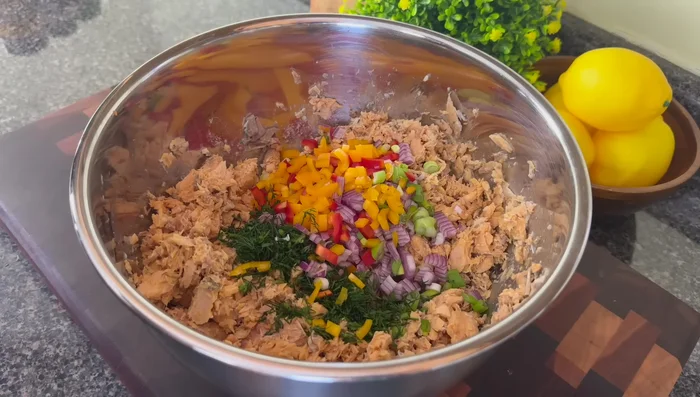 Ajouter les légumes, l'huile d'avocat, la mayonnaise, la moutarde de Dijon, le jus de citron, les œufs, l'assaisonnement créole, le poivre de Cayenne et le poivre noir au saumon.