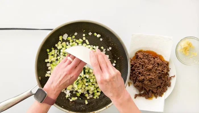 Faire cuire les oignons et les courgettes dans la même poêle (à feu moyen-élevé) jusqu'à ce qu'ils ramollissent. Assaisonner avec du sel. (206.519)