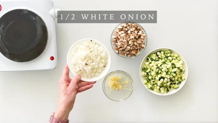 Couper les légumes : oignon finement haché, champignons finement hachés, courgettes en dés, ail émincé. Mettre de côté. (43.92)