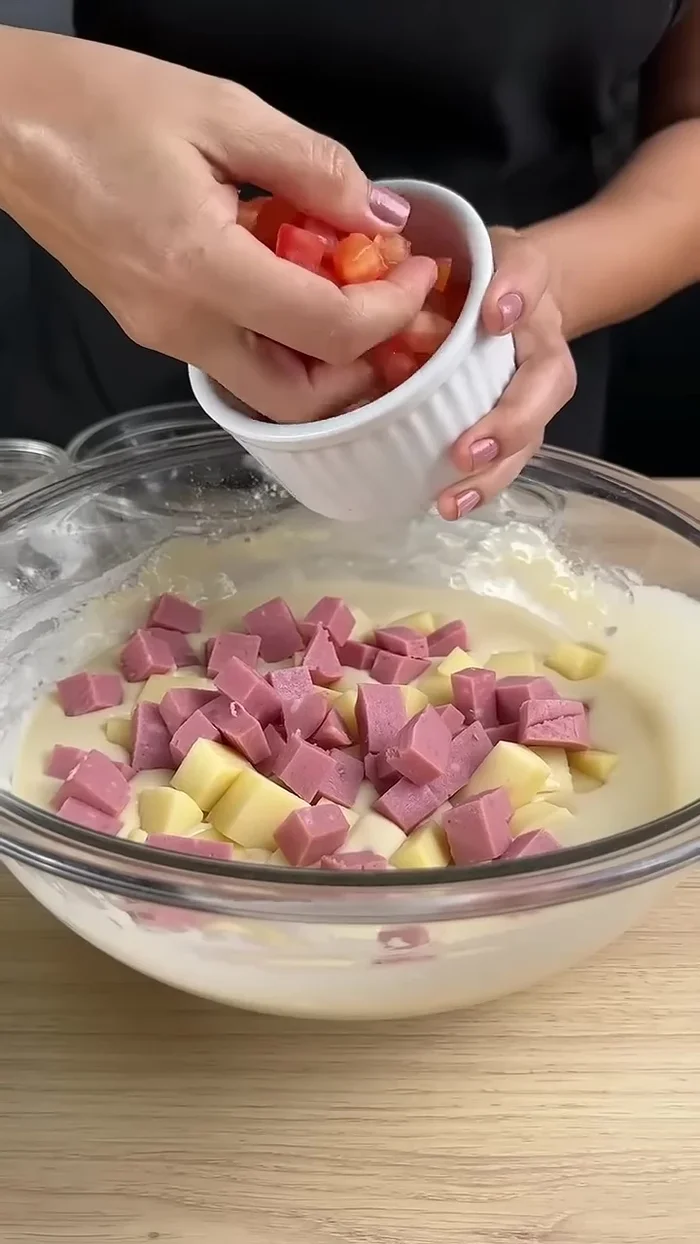 Ajoutez la tomate (coupée en petits morceaux), une partie dans la pâte et réservez le reste pour la décoration.