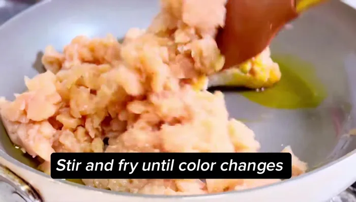 Faire revenir le poulet haché avec de l'huile, du sel, la pâte d'ail, la pâte de gingembre, et le piment vert. Couvrir et cuire 5 minutes.