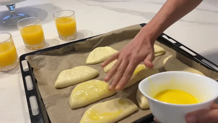 Enfourner les pains à 180°C pendant 15 à 20 minutes. Battre un jaune d'oeuf avec un peu de lait pour badigeonner les pains avant la cuisson. Ajouter des graines de sésame et de nigelle pour la décoration.