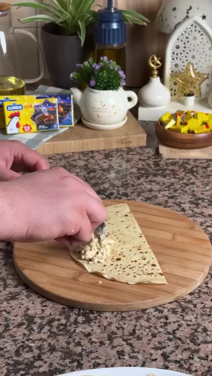 Farcir les crêpes: Étaler la farce sur les crêpes, puis ajouter du fromage râpé.