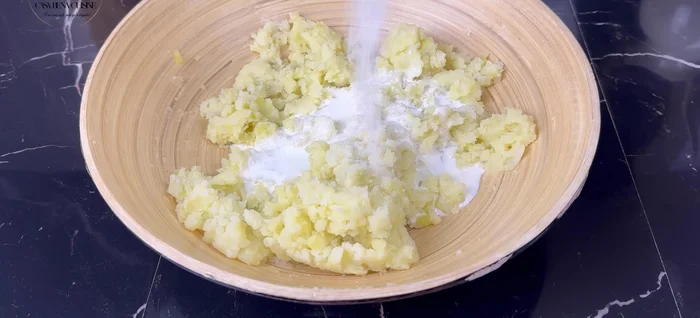 Ajouter la crème liquide, le sel, le poivre, le persil/ciboulette et une noisette de beurre aux pommes de terre écrasées. Bien mélanger.