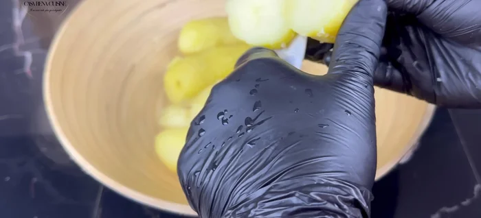 Éplucher et couper les pommes de terre chaudes en morceaux. Les écraser à l'aide d'un presse-purée.