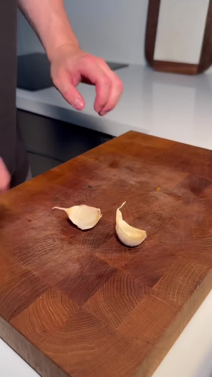 Préparer la garniture aromatique : couper une carotte en biseau, écraser deux gousses d'ail et ciseler grossièrement un oignon blanc.