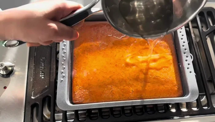 Verser le sirop sur le Basbousa chaud.