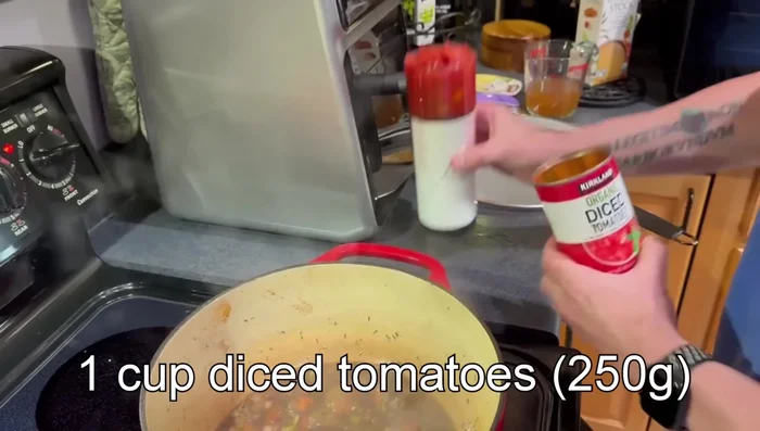 Ajouter les tomates en dés et le bouillon de poulet. Porter à ébullition.